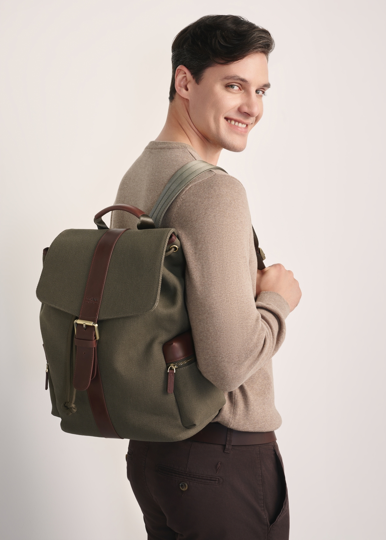 Plecak męski w kolorze khaki TORMN-0371-55(Z25) - widok produktu lekko po skosie na modelu na białym tle. Widoczna połowa sylwetki. 