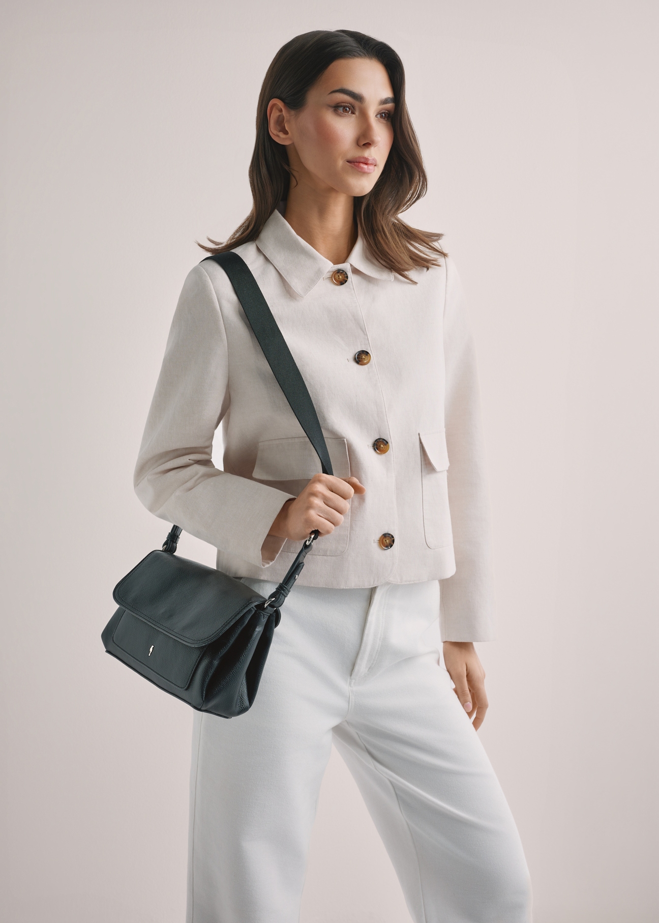 Czarna klasyczna torebka damska TOREC-1124-99(W26), widok produktu z przodu na ramieniu modelki. Widoczna połowa sylwetki.