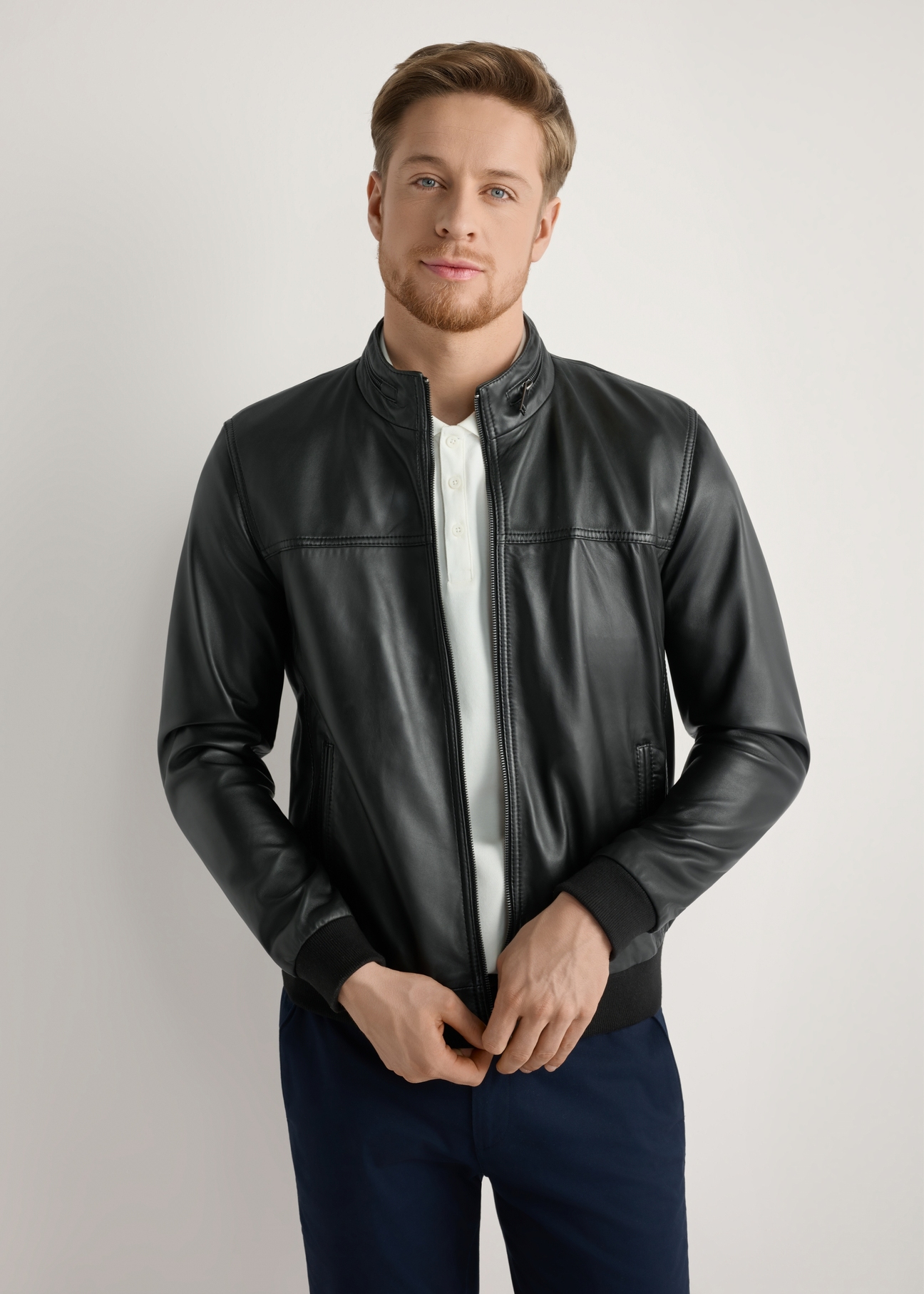 Czarna skórzana kurtka męska KURMS-0392-99(W26) - widok produktu z przodu, na modelu, na jasnym tle. Widoczna połowa sylwetki.