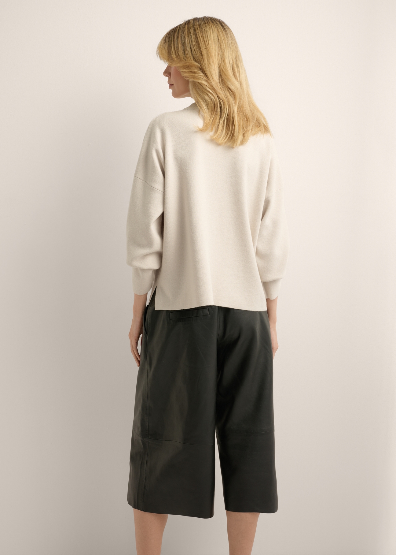 Jasnobeżowy sweter damski SWEDT-0263-1A(Z26), widok produktu z tyłu na modelce. Widoczna połowa sylwetki.