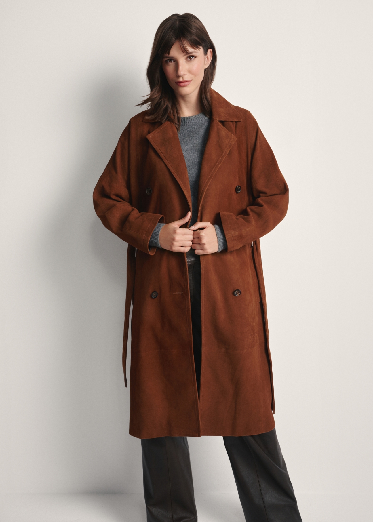 Brązowy zamszowy płaszcz damski oversize KURDS-0551-0775(Z25), widok produktu z przodu na modelce. Widoczna połowa sylwetki.