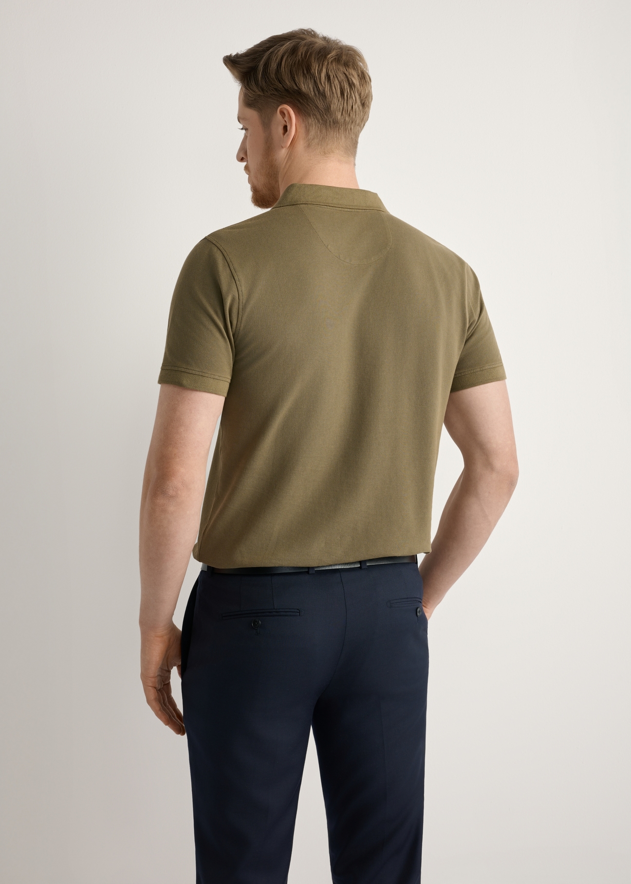 Męska koszulka polo w kolorze khaki POLMT-0055A-8D(W26), widok produktu z tyłu na modelu. Widoczna połowa sylwetki.