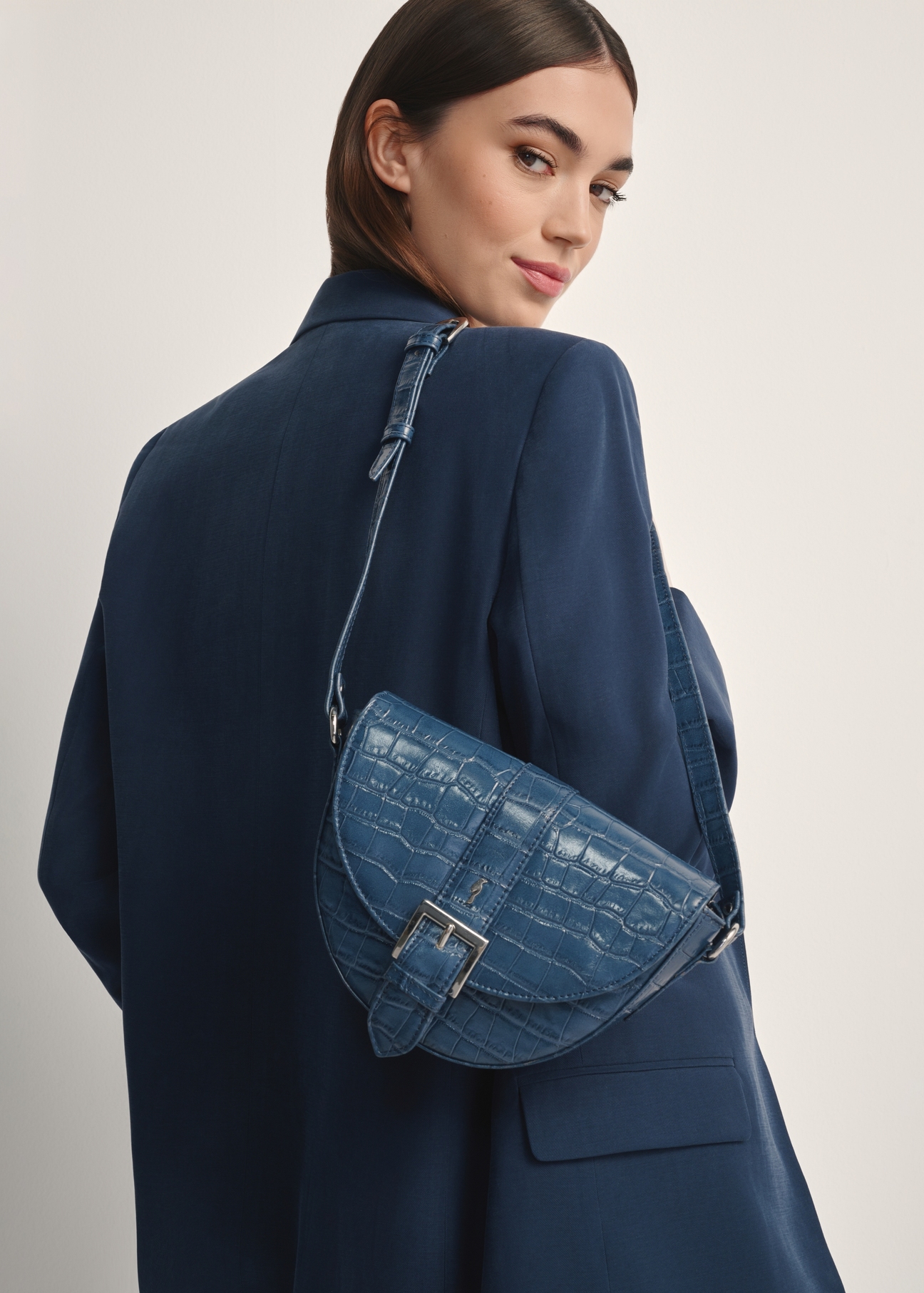Granatowa skórzana torebka w stylu croco TORES-0707F-7D(W26), widok produktu od przodu na modelu, widoczna połowa sylwetki.