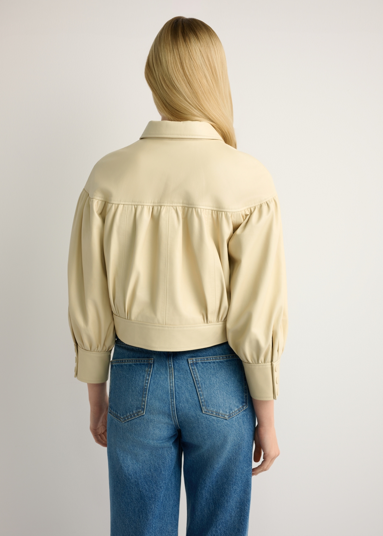 Skórzana jasnożółta kurtka damska KURDS-0574-2A(W26), widok produktu z tyłu na modelce. Widoczna połowa sylwetki.