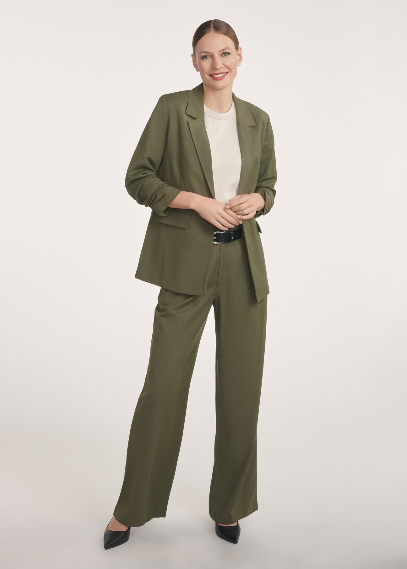 Marynarka damska w kolorze khaki ZAKDT-0043-55(Z25), widok produktu z przodu na modelce. Widoczna cała sylwetka.