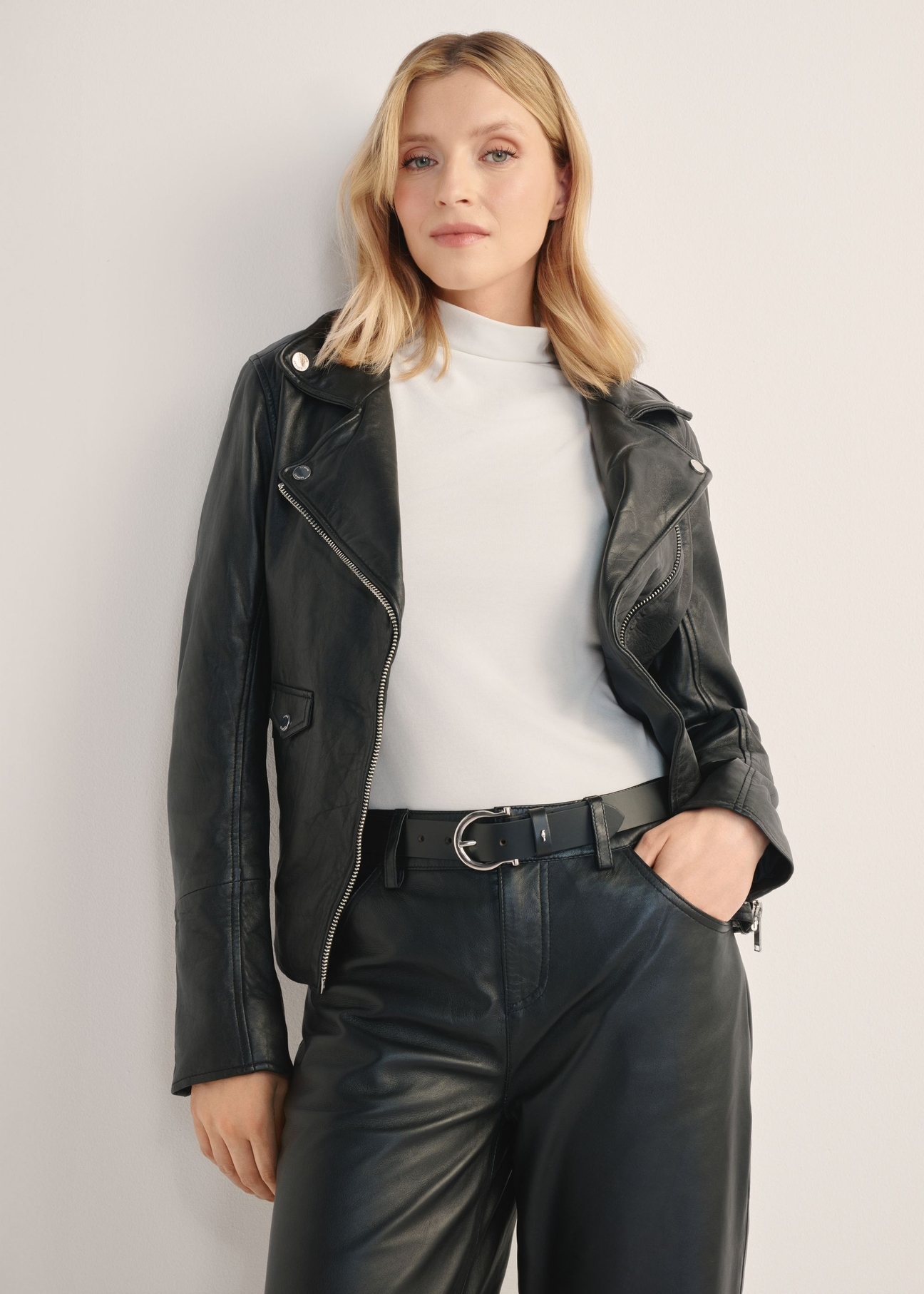 Skórzana kurtka damska w kolorze czarnym KURDS-0184-99(KS), widok produktu z przodu na modelce. Widoczna połowa sylwetki.