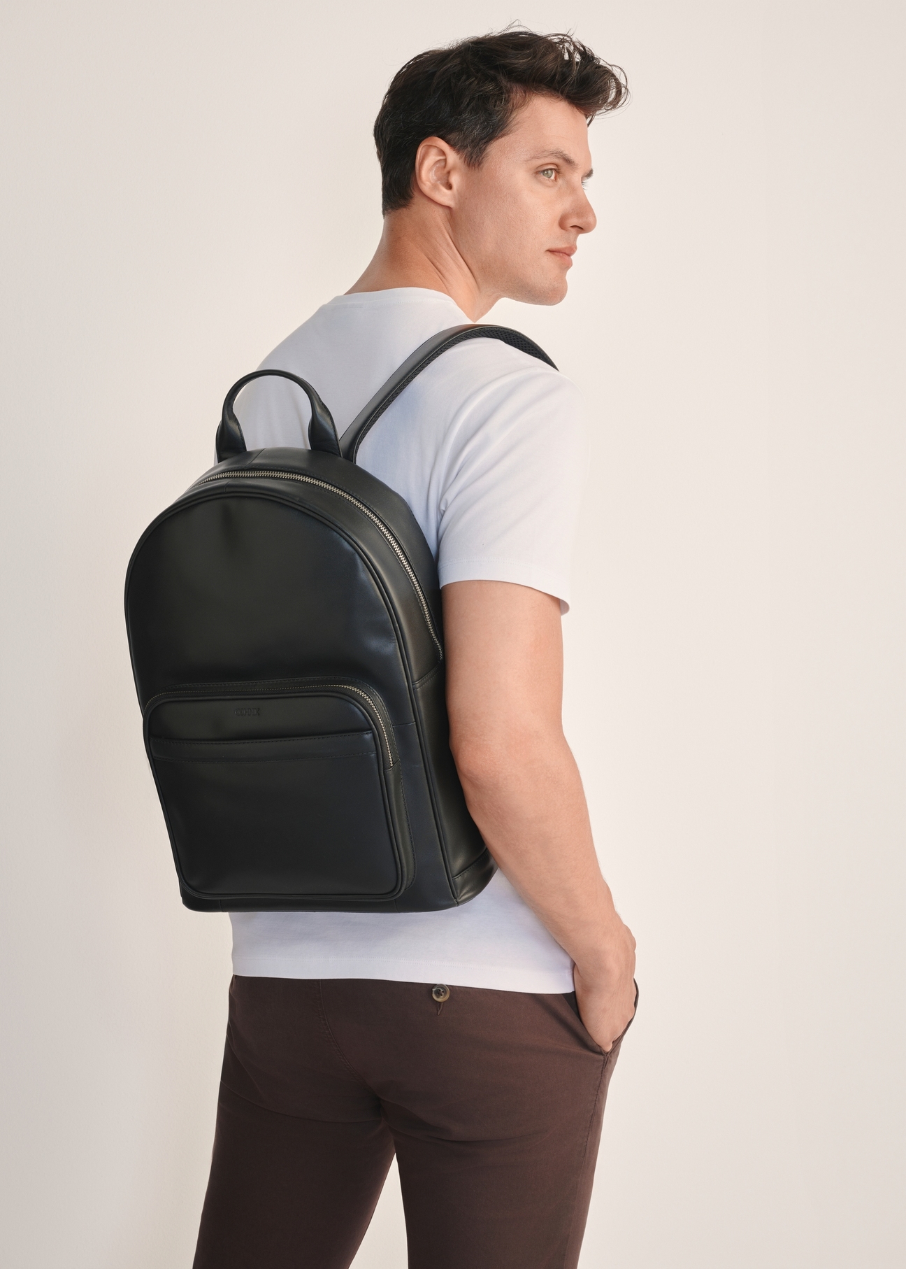 Czarny skórzany plecak męski TORMS-0472-99(Z25), widok produktu od przodu na modelu, widoczna połowa sylwetki.