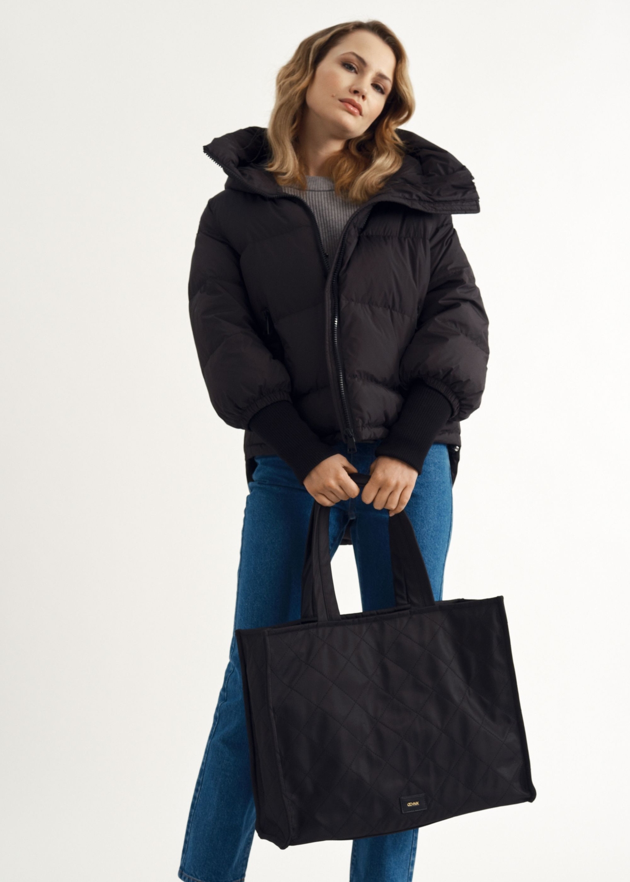 Torebka damska typu tote bag TOREN-0268A-99(Z25), widok produktu w rękach modelki. Widoczna połowa sylwetki.