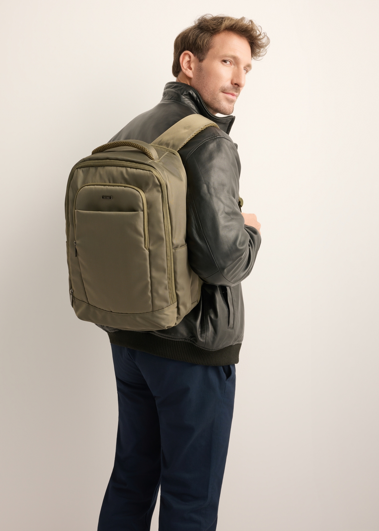 Plecak do samolotu w kolorze khaki PLCMN-0014-8D(Z26), widok produktu od przodu na modelu, widoczna połowa sylwetki.