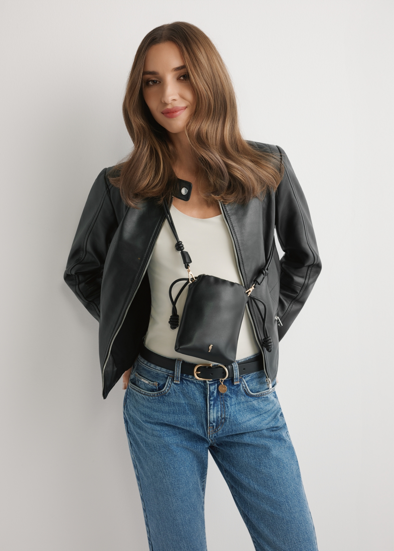 Czarna saszetka na telefon TOREC-1216-99(W26) - widok produktu z przodu, na modelce, na jasnym tle. Widoczna połowa sylwetki.