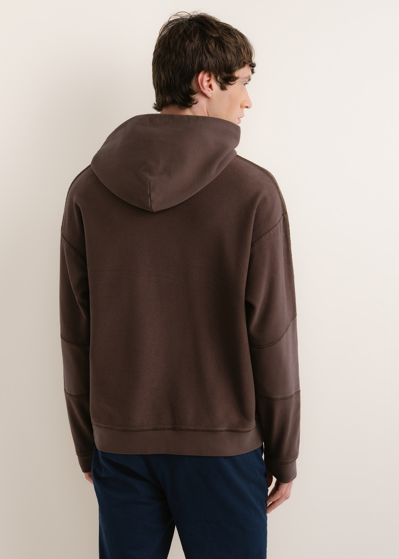 Ciemnobrązowa bawełniana bluza męska z kapturem BLZMT-0086-1I(Z26), widok produktu od tyłu na modelu. Widoczna połowa sylwetki.