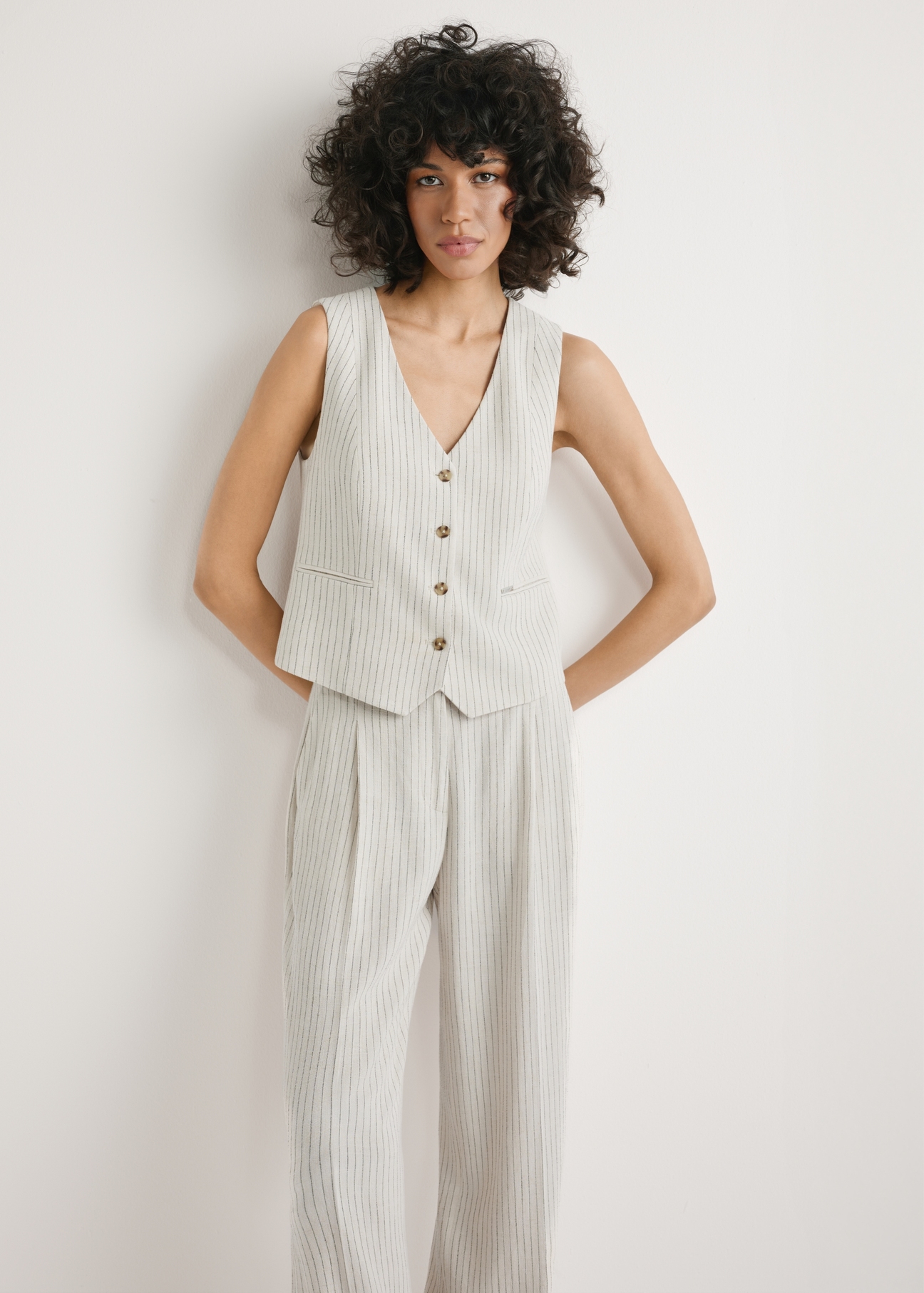 Kamizelka damska z wiskozy KAMDT-0037-0P(W26) - widok produktu z przodu, na modelce, na jasnym tle. Widoczna sylwetka do kolan. 