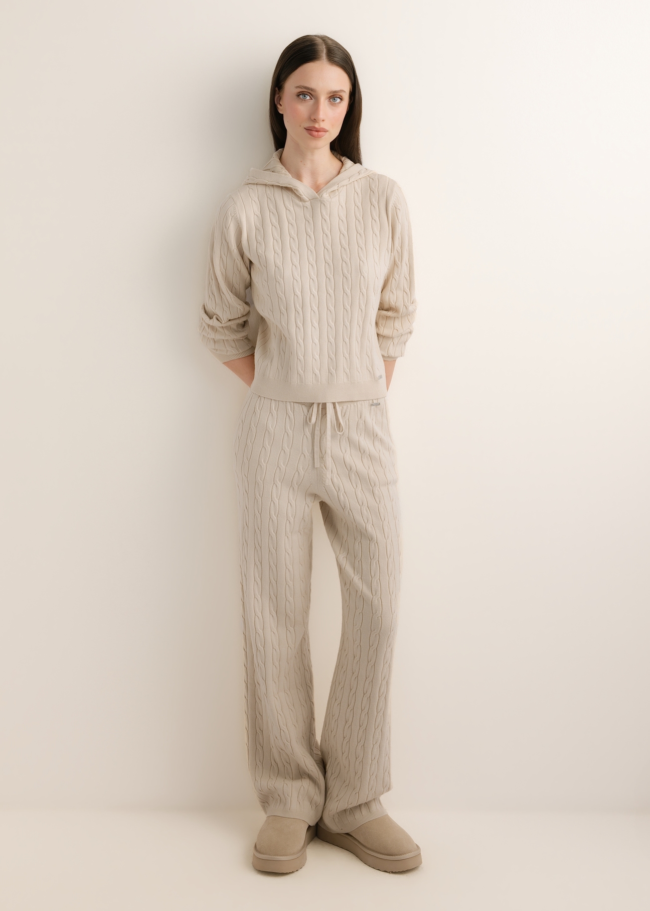 Beżowy sweter damski z kapturem BLZDT-0124-1A(Z26), widok produktu z przodu na modelce. Widoczna cała sylwetka. 