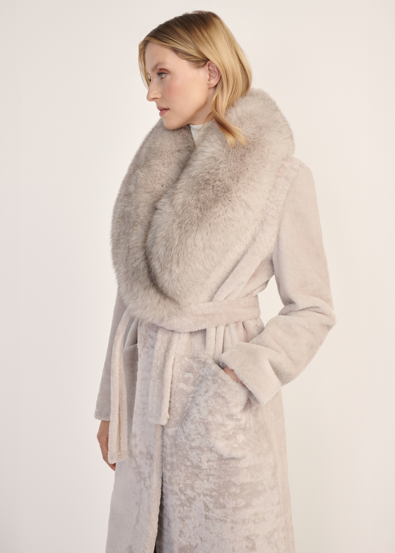 Jasnobeżowy dwustronny długi kożuch damski KOZDS-0089-3037(Z25) - widok produktu z przodu na białym tle. Widoczna połowa sylwetki. 