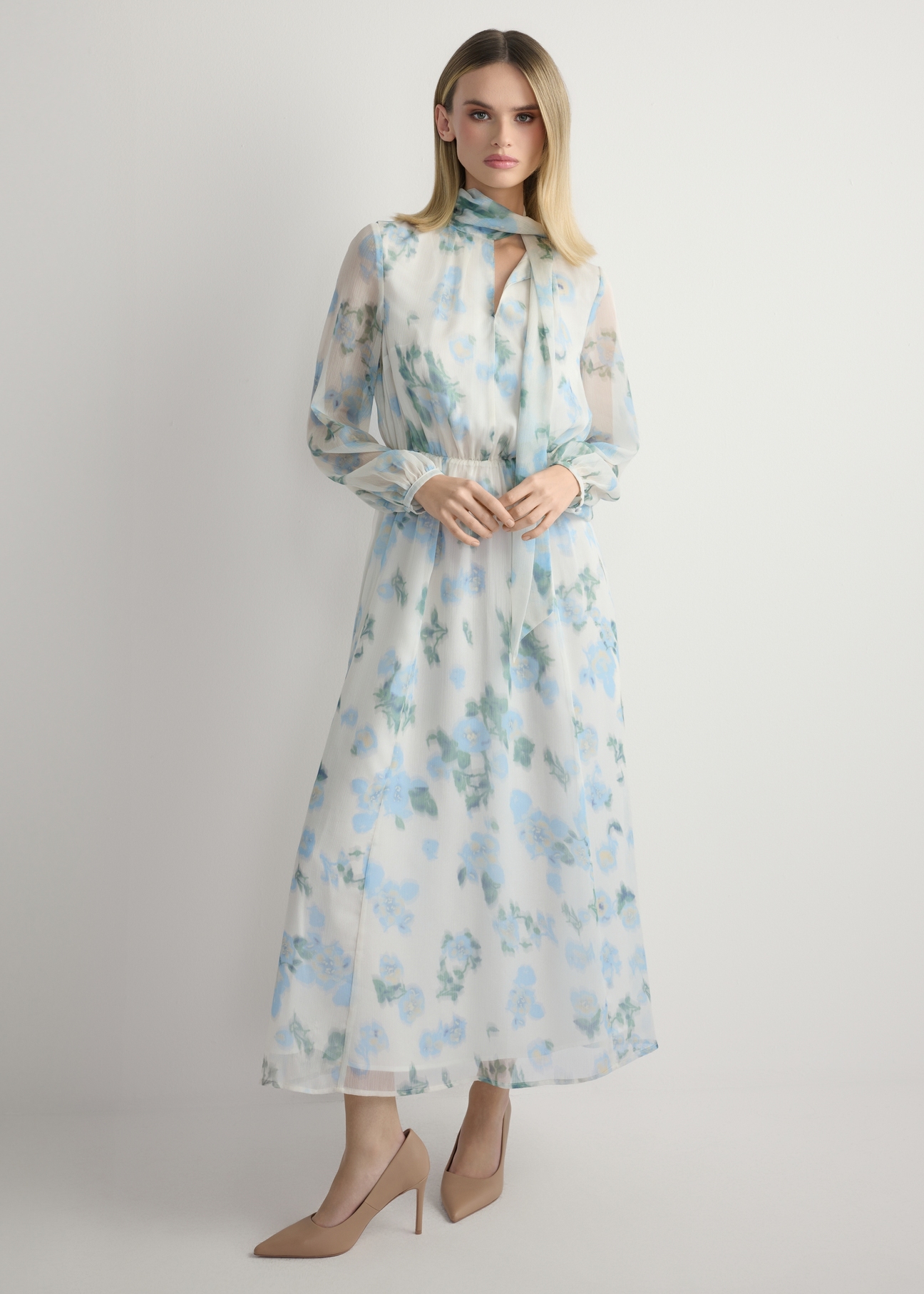 Kremowa sukienka damska w kwiaty SUKDT-0265-7P(W26), widok produktu z przodu na modelce. Widoczna cała sylwetka.