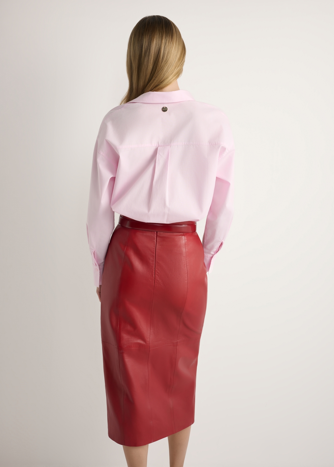 Jasnoróżowa bawełniana koszula damska KOSDT-0181-5A(W26), widok produktu z tyłu na modelce. Widoczna połowa sylwetki.