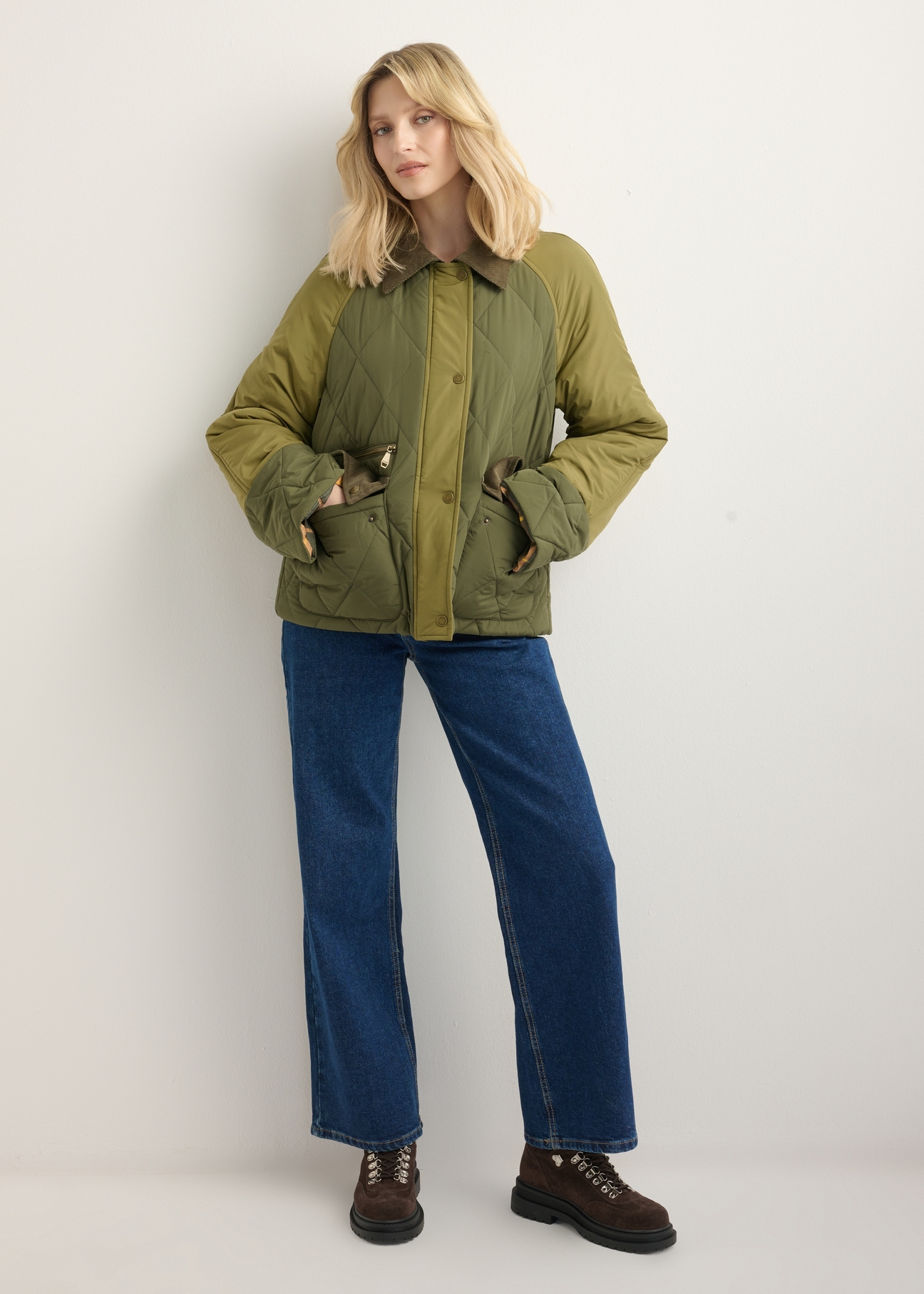 Kurtka damska w kolorze khaki KURDT-0665-8B(Z26), widok produktu z przodu na modelce. Widoczna cała sylwetka.