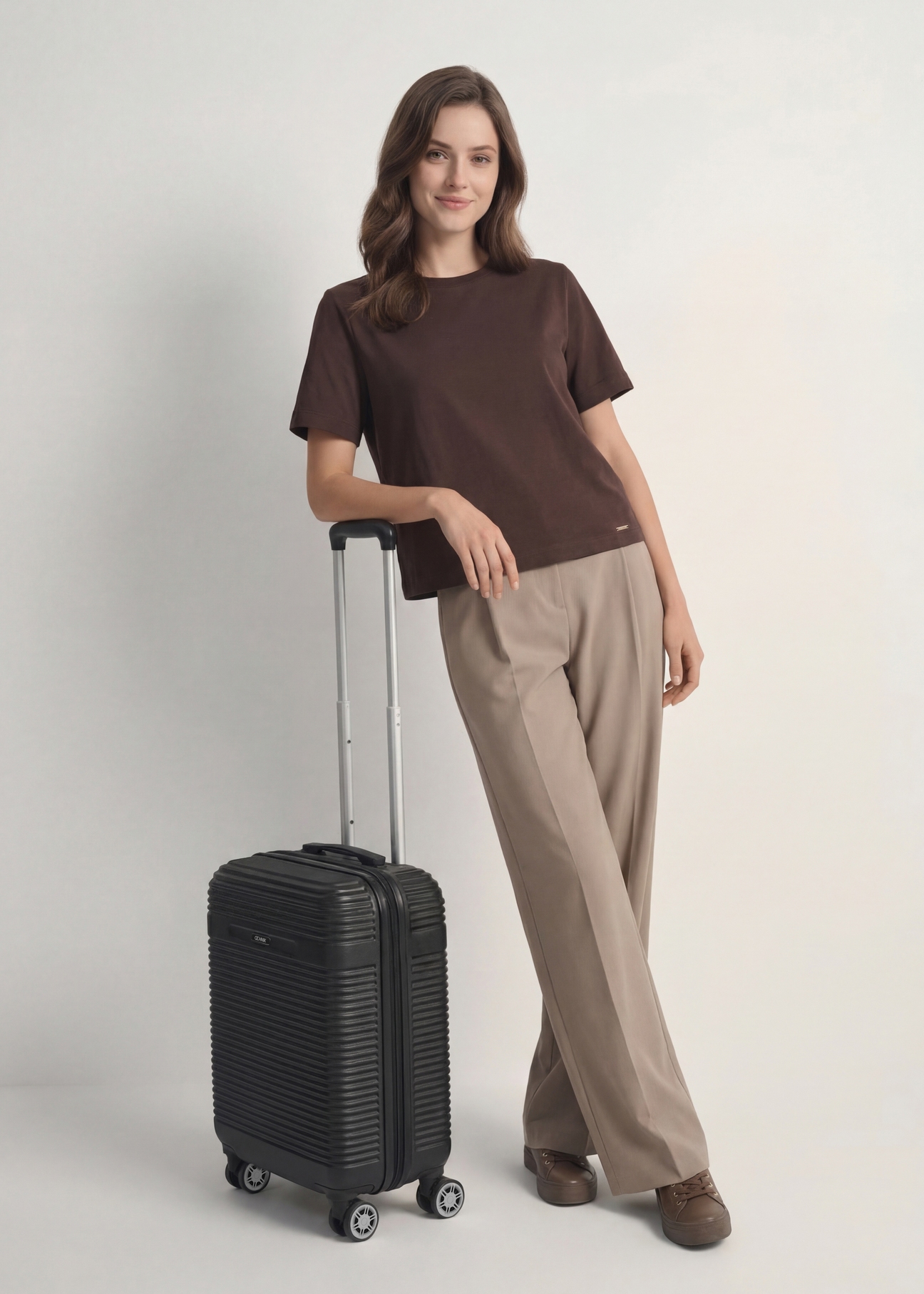 Walizka mała na kółkach  WALAB-0040-99-19(W25), widok produktu skosem przy modelce, widoczna cała sylwetka.