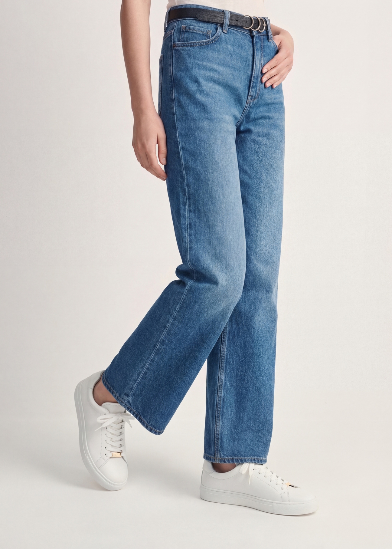 Białe skórzane tenisówki damskie BUTYD-1068-0B(W26), widok produktu z boku na stopach modelki.