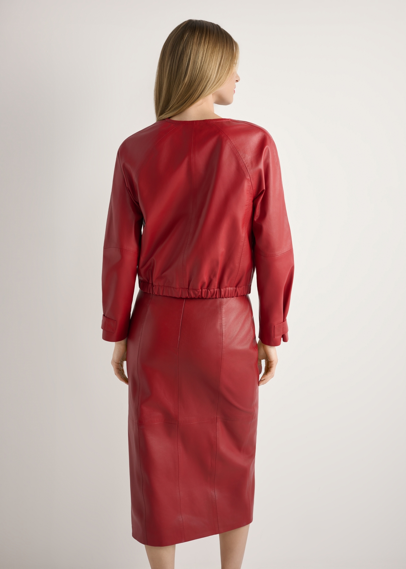 Skórzana kurtka damska w kolorze czerwonym KURDS-0588-4B(W26), widok produktu z tyłu na modelce. Widoczna połowa sylwetki.