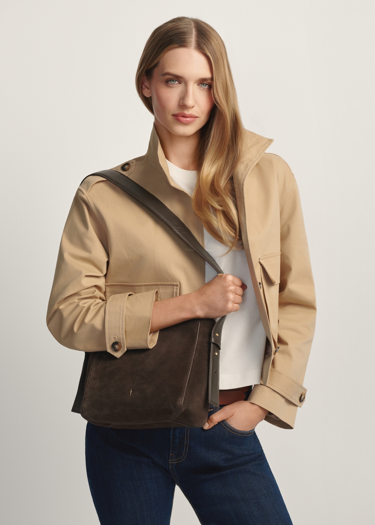 Skórzana torebka damska w kolorze brązowym TORES-1251-1I(W26) - widok produktu po skosie, na modelce, na jasnym tle. Widoczna sylwetka do kolan.