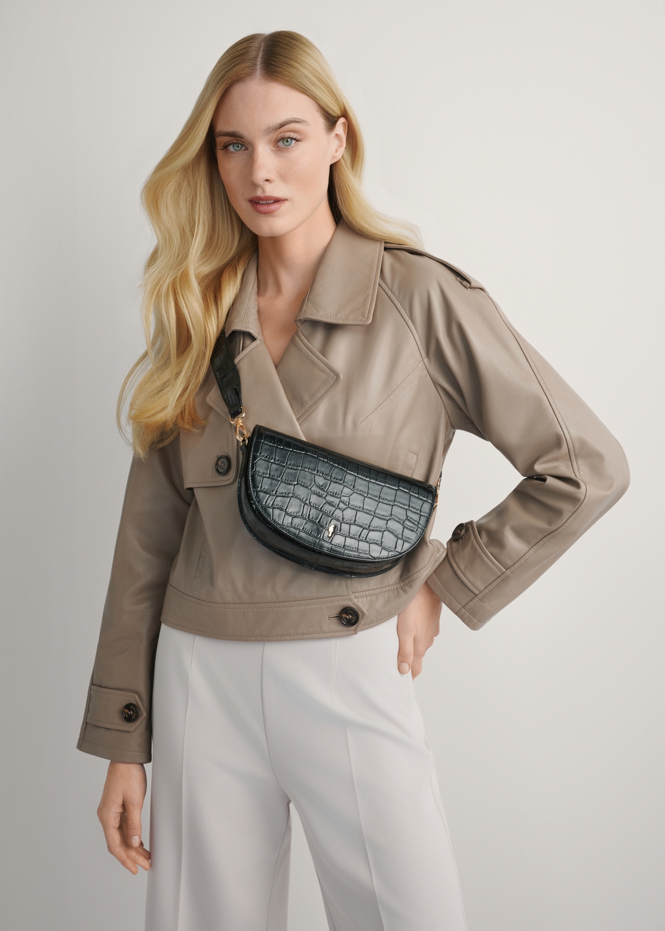 Czarna skórzana półokrągła listonoszka croco TORES-1230-9G(W26), widok produktu na ramieniu modelki. Widoczna połowa sylwetki.