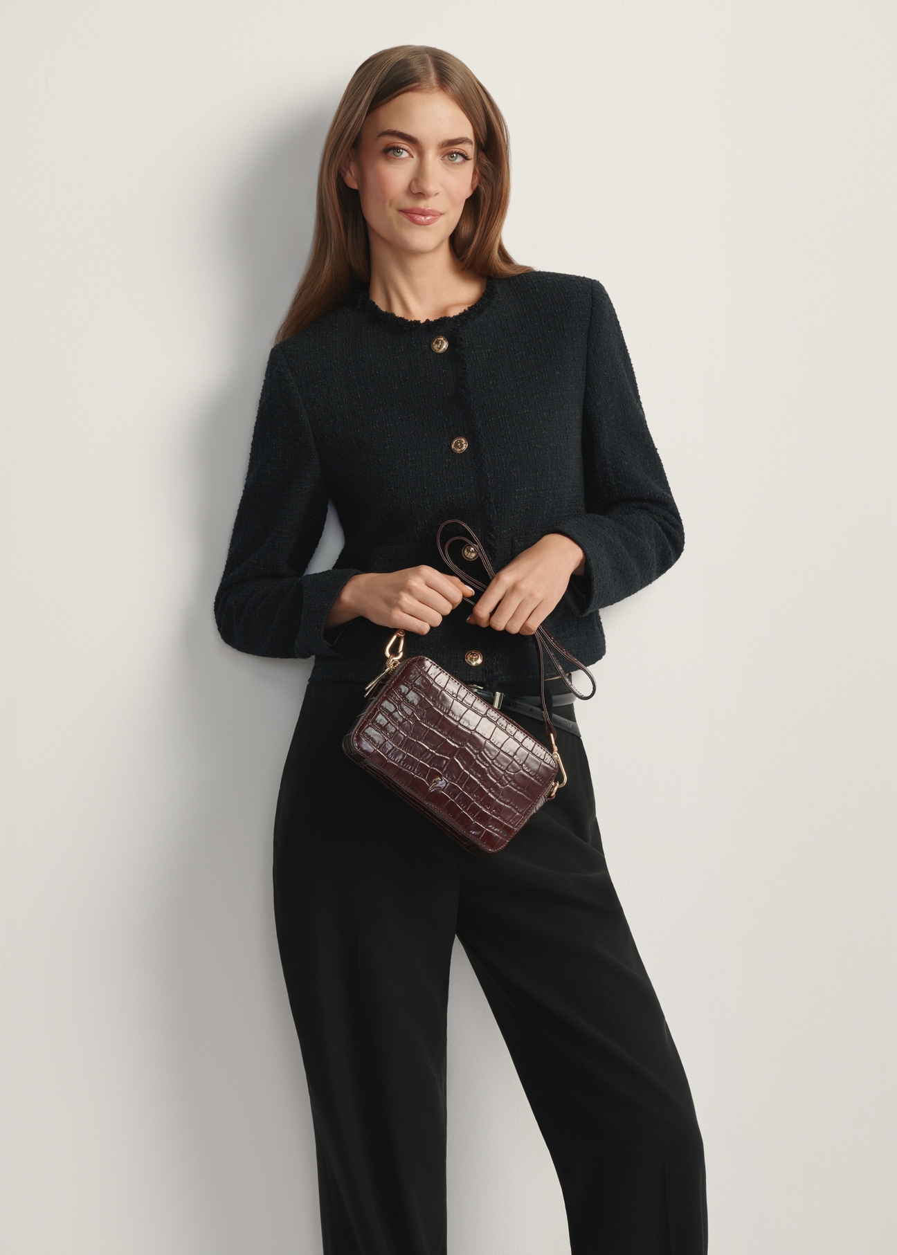 Mała brązowa skórzana torebka croco TORES-1231-1H(W26) - widok produktu z przodu, na modelce, na jasnym tle. Widoczna sylwetka do kolan.