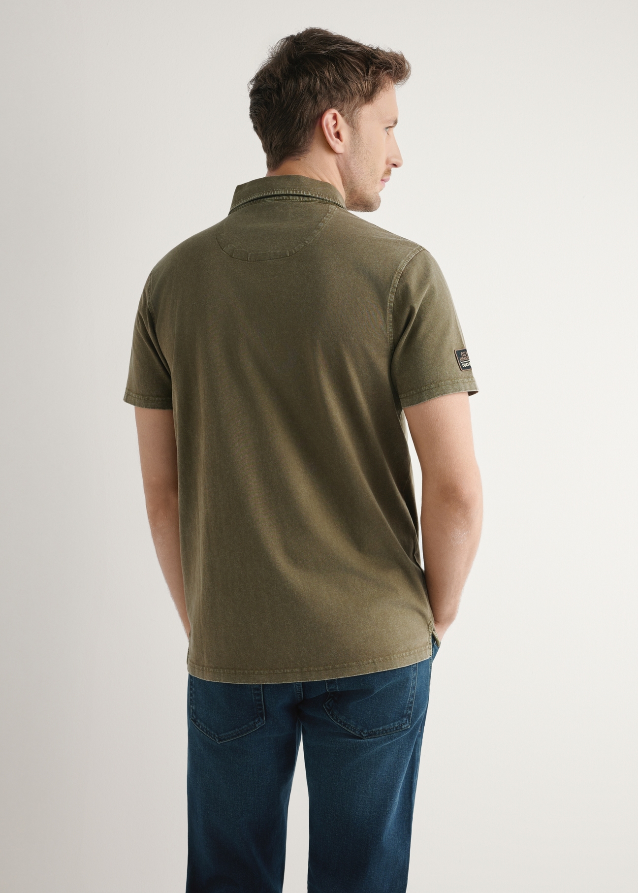 Koszulka polo męska w kolorze khaki POLMT-0083-8D(W26), widok produktu z tyłu na modelu. Widoczna połowa sylwetki.