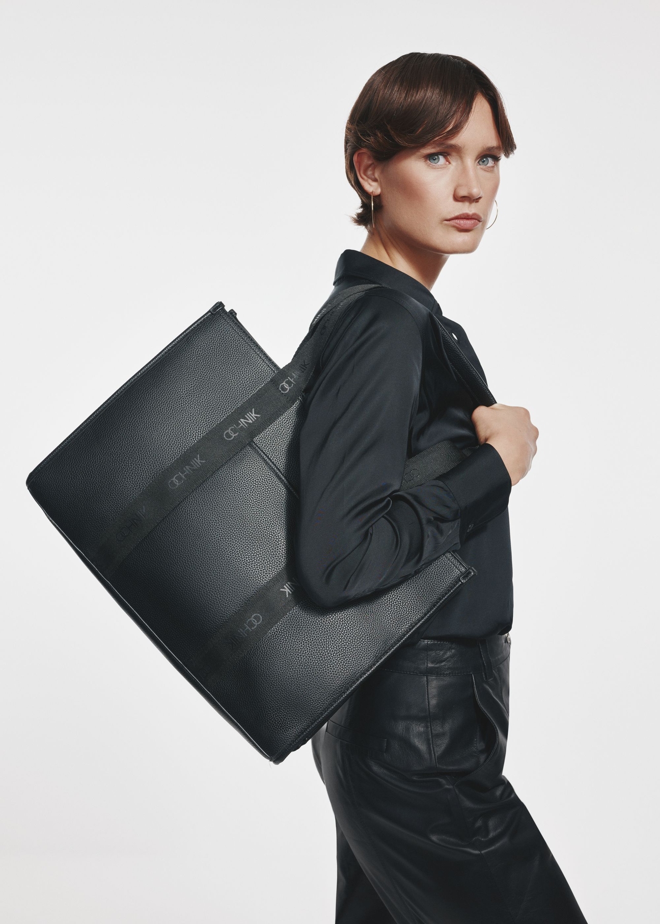 Czarna duża torebka shopper TOREC-0977A-99(Z25) - widok produktu z przodu na modelce na białym tle.