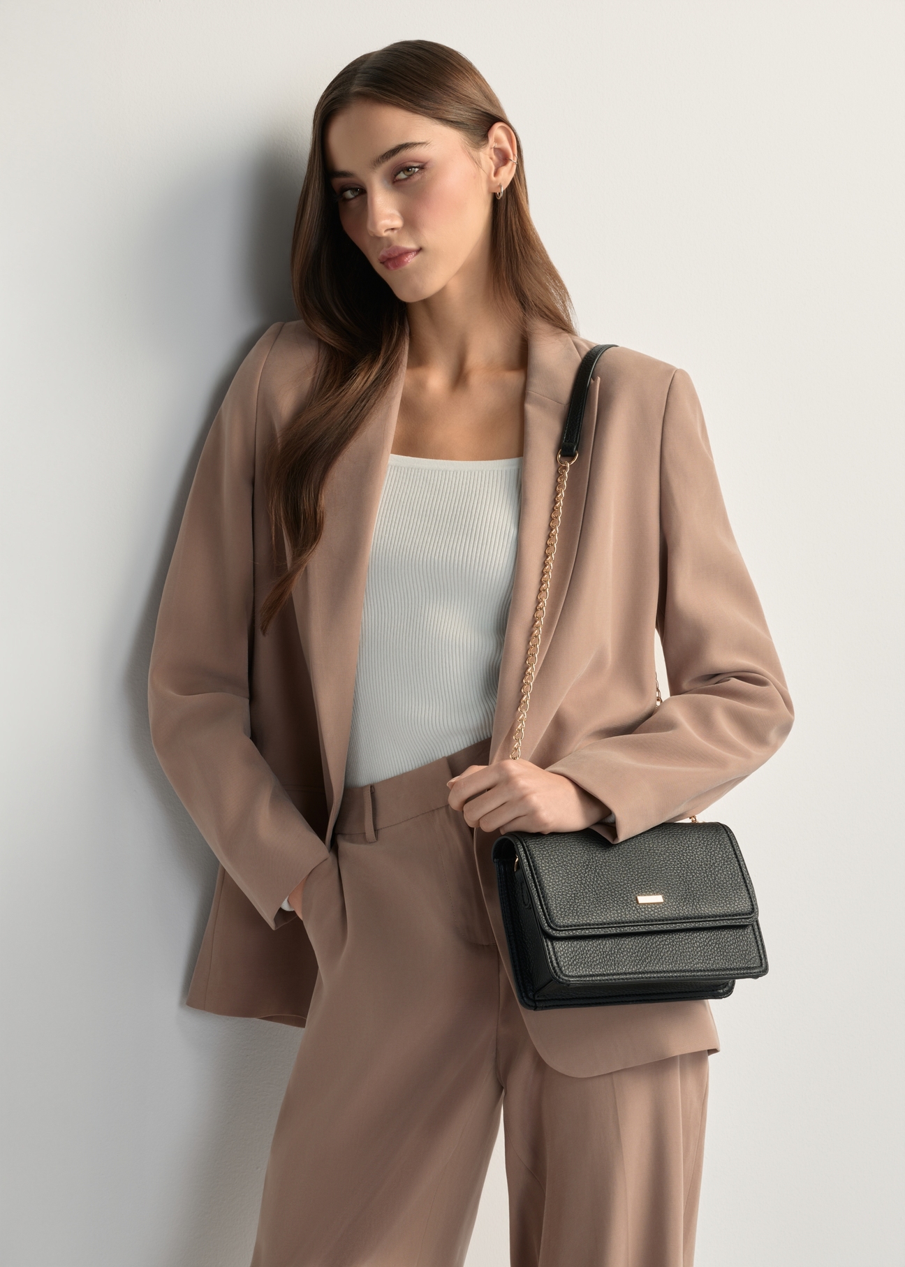 Niewielka elegancka torebka damska TOREC-1015-99(W26), widok produktu od przodu na modelce, widoczna połowa sylwetki.