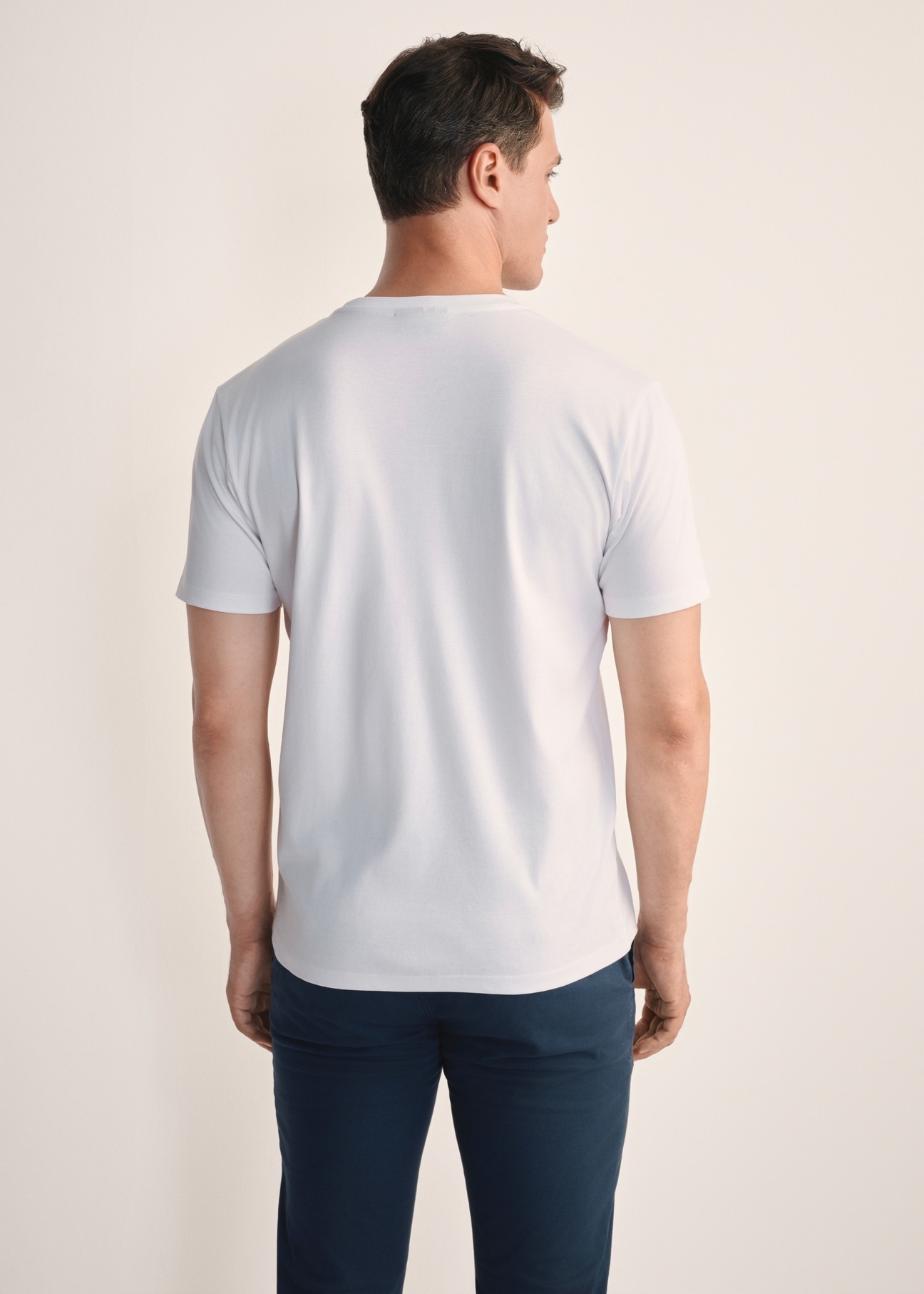 Biały T-shirt męski z bawełny merceryzowanej TSHMT-0135-11(Z25), widok produktu z tyłu na modelu. Widoczna połowa sylwetki.