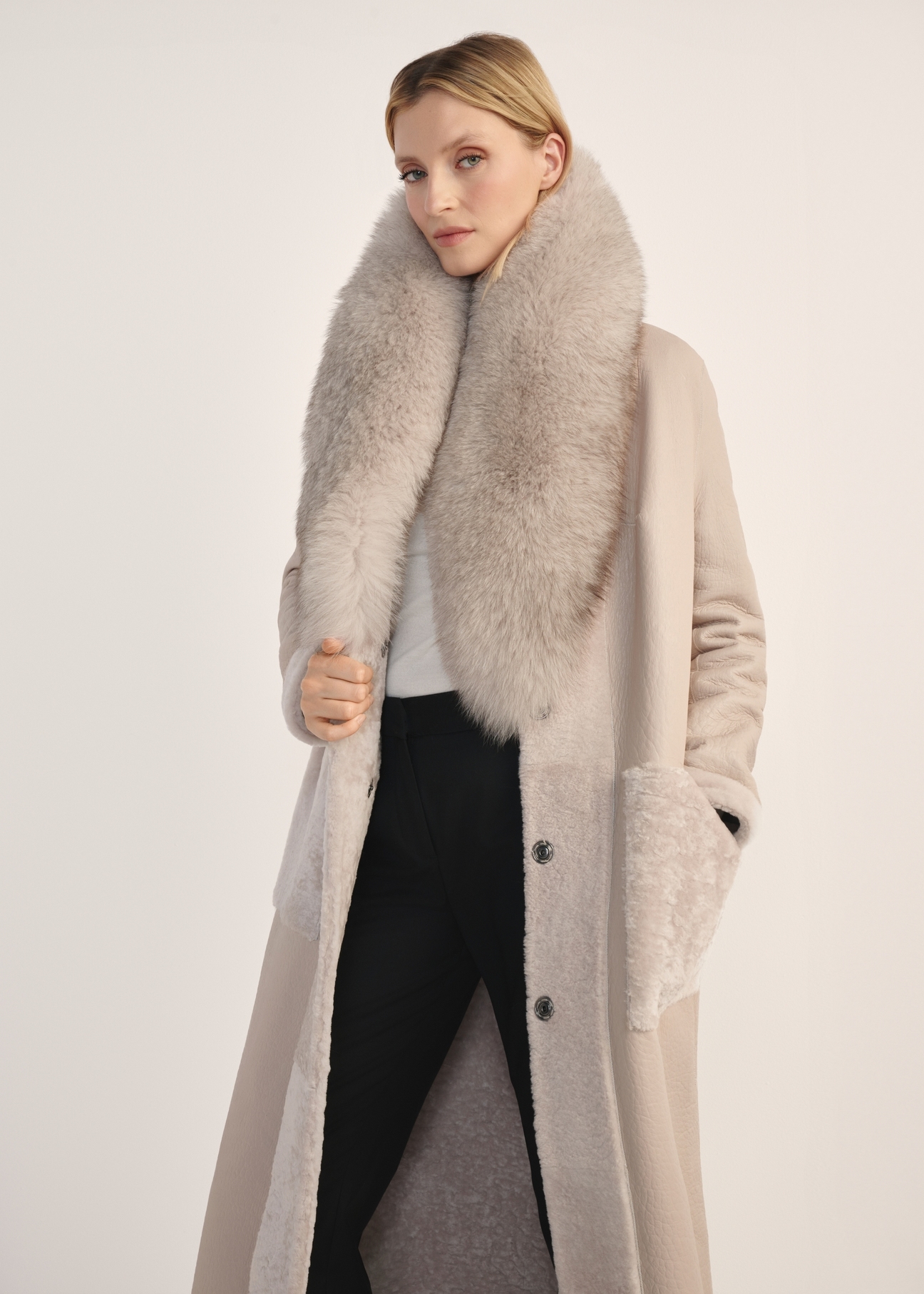 Jasnobeżowy dwustronny długi kożuch damski KOZDS-0089-3037(Z25) - widok produktu z przodu na białym tle. Widoczna sylwetka do kolan. 