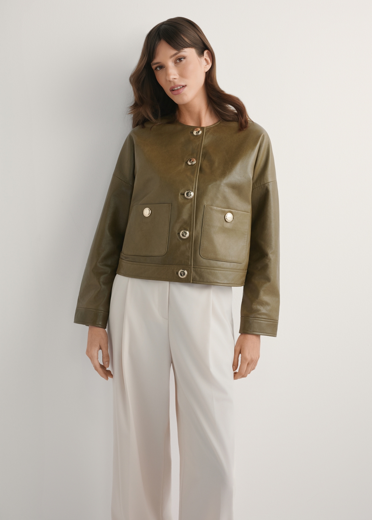 Krótka skórzana kurtka damska khaki KURDS-0590-8D(W26), widok produktu z przodu na modelce. Widoczna połowa sylwetki.