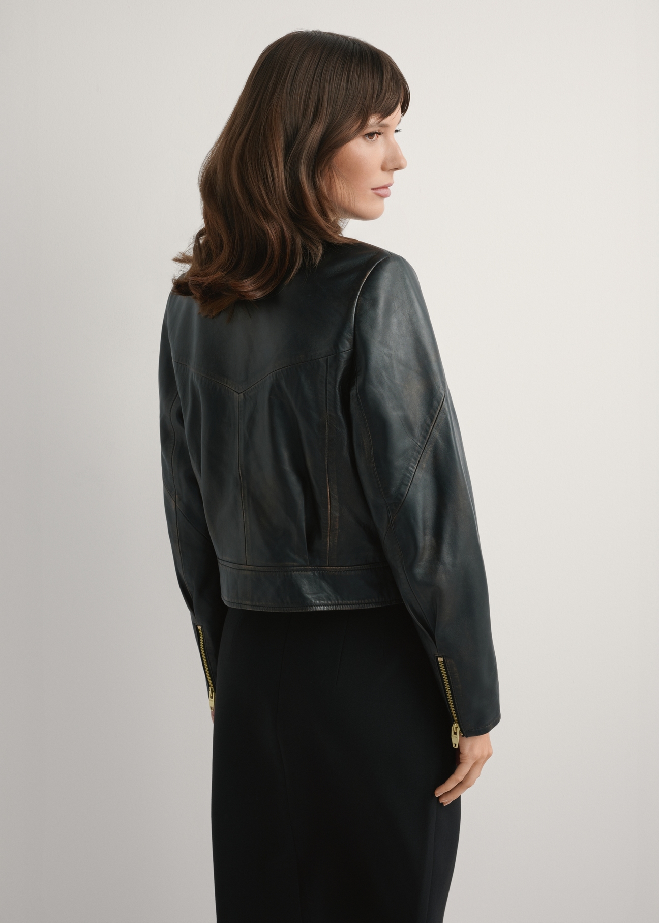 Krótka skórzana kurtka damska vintage KURDS-0573-9J(W26), widok produktu z tyłu na modelce. Widoczna połowa sylwetki.