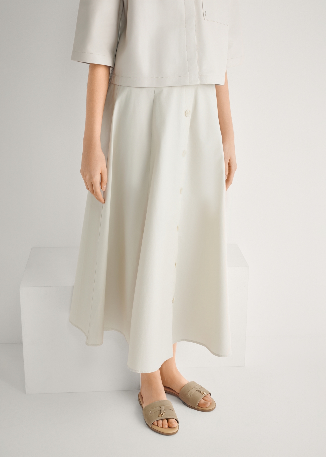 Zamszowe klapki damskie w kolorze chłodnego beżu BUTYD-1255-1K(W26), widok produktu z przodu na stopach modelki.