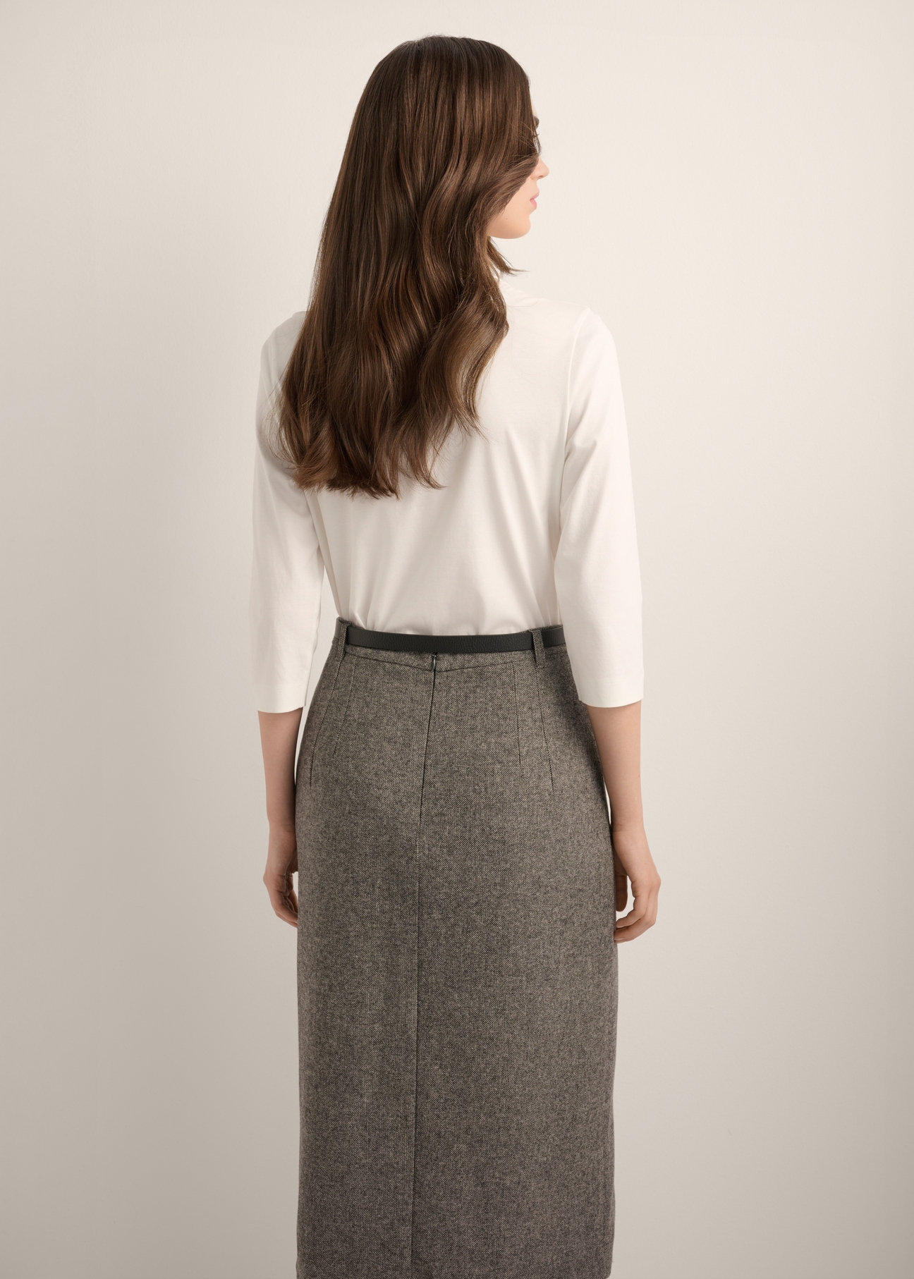 Kremowa bawełniana bluzka z dekoltem V-neck BLUDT-0210-0B(Z26), widok produktu z tyłu na modelce. Widoczna połowa sylwetki.