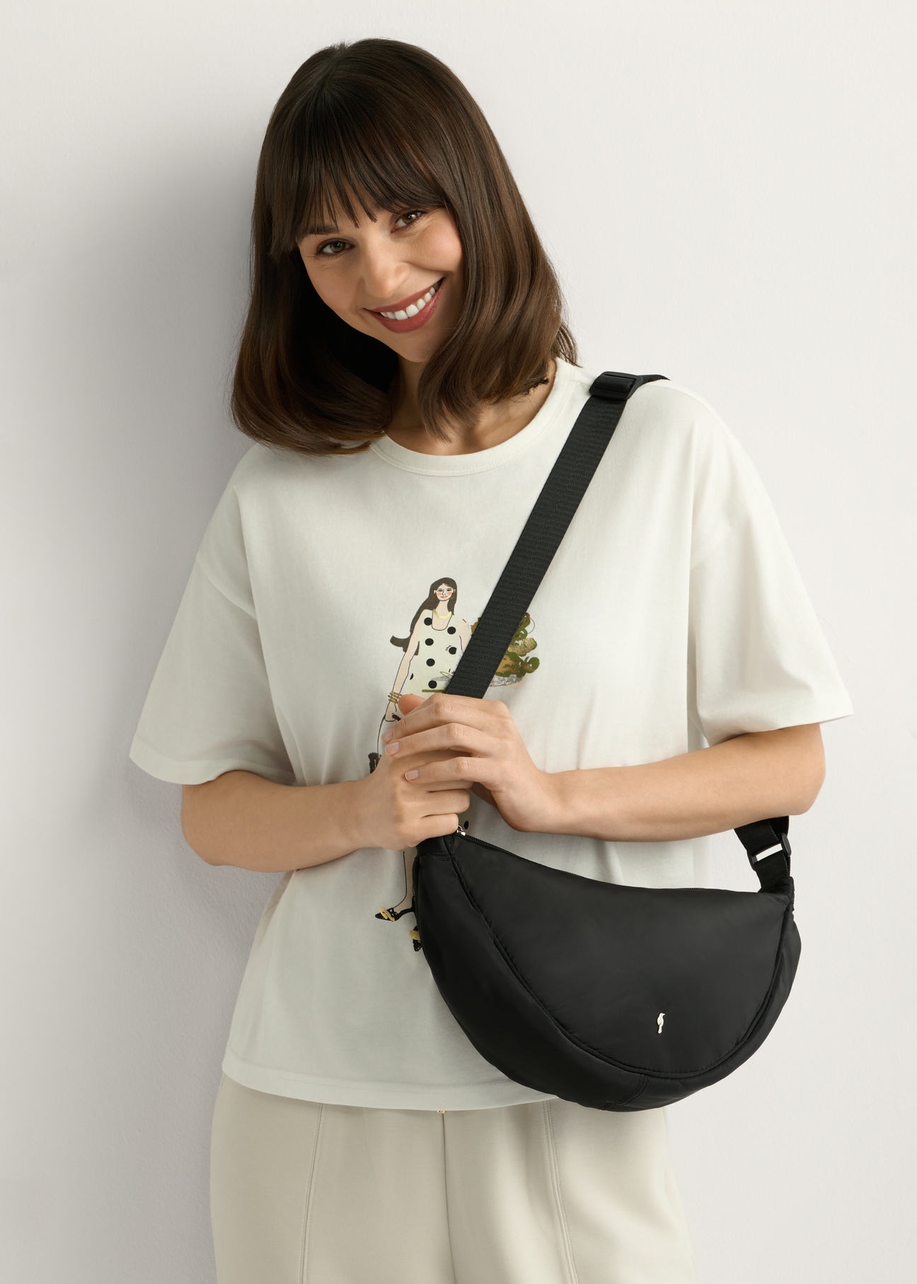 Czarna nylonowa torebka damska TOREN-0342-99(W26) - widok produktu z przodu, na modelce, na białym tle. 