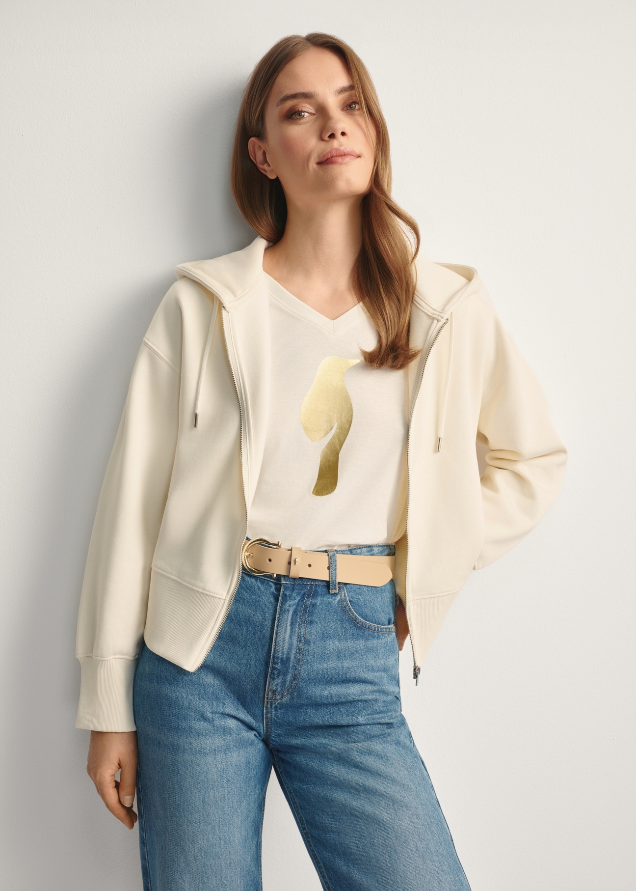 Kremowa bluza damska z kapturem BLZDT-0113-12(Z25), widok produktu przodem na modelce, widoczna połowa sylwetki.