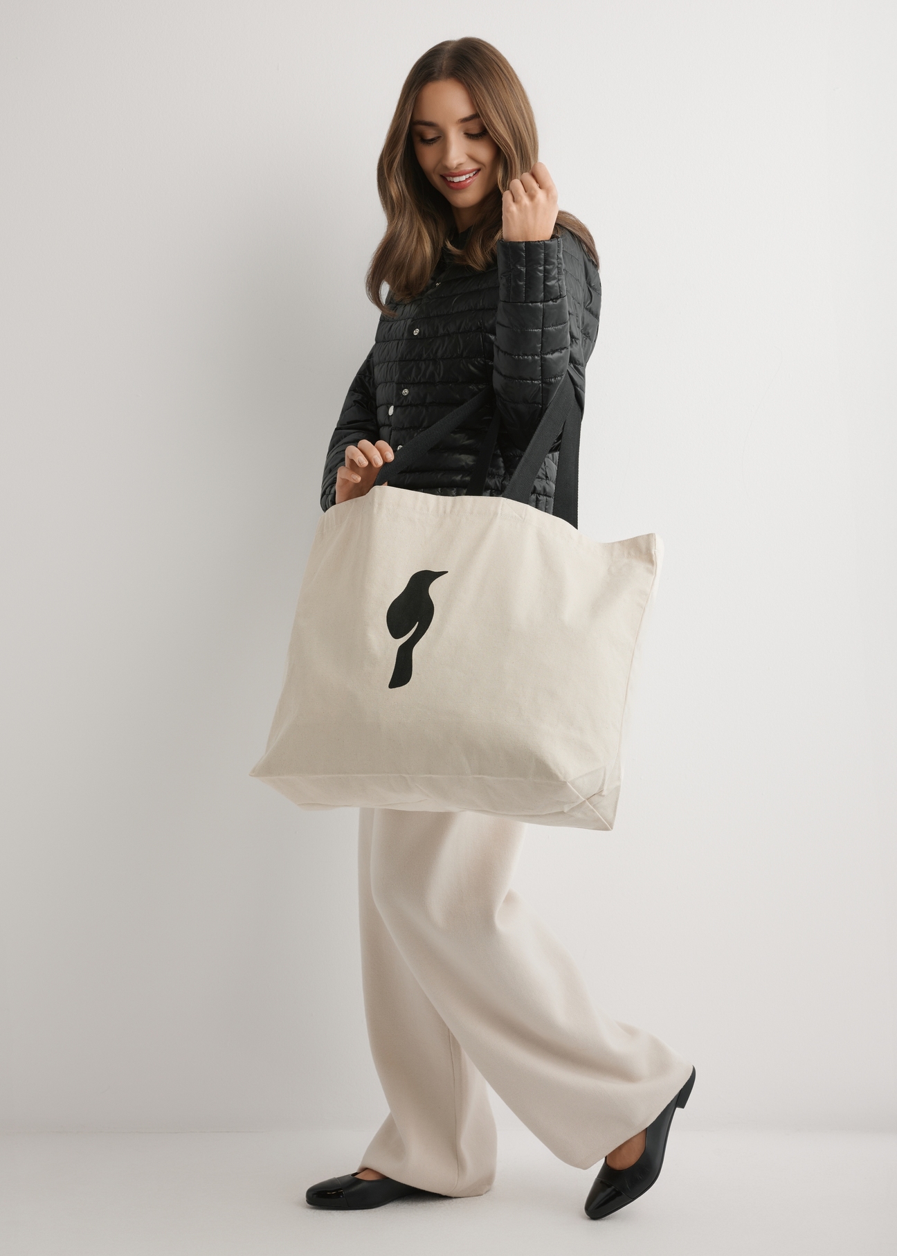 Kremowa bawełniana torba TOREN-0136-0C(W26), widok produktu na ramieniu modelki. Widoczna cała sylwetka.