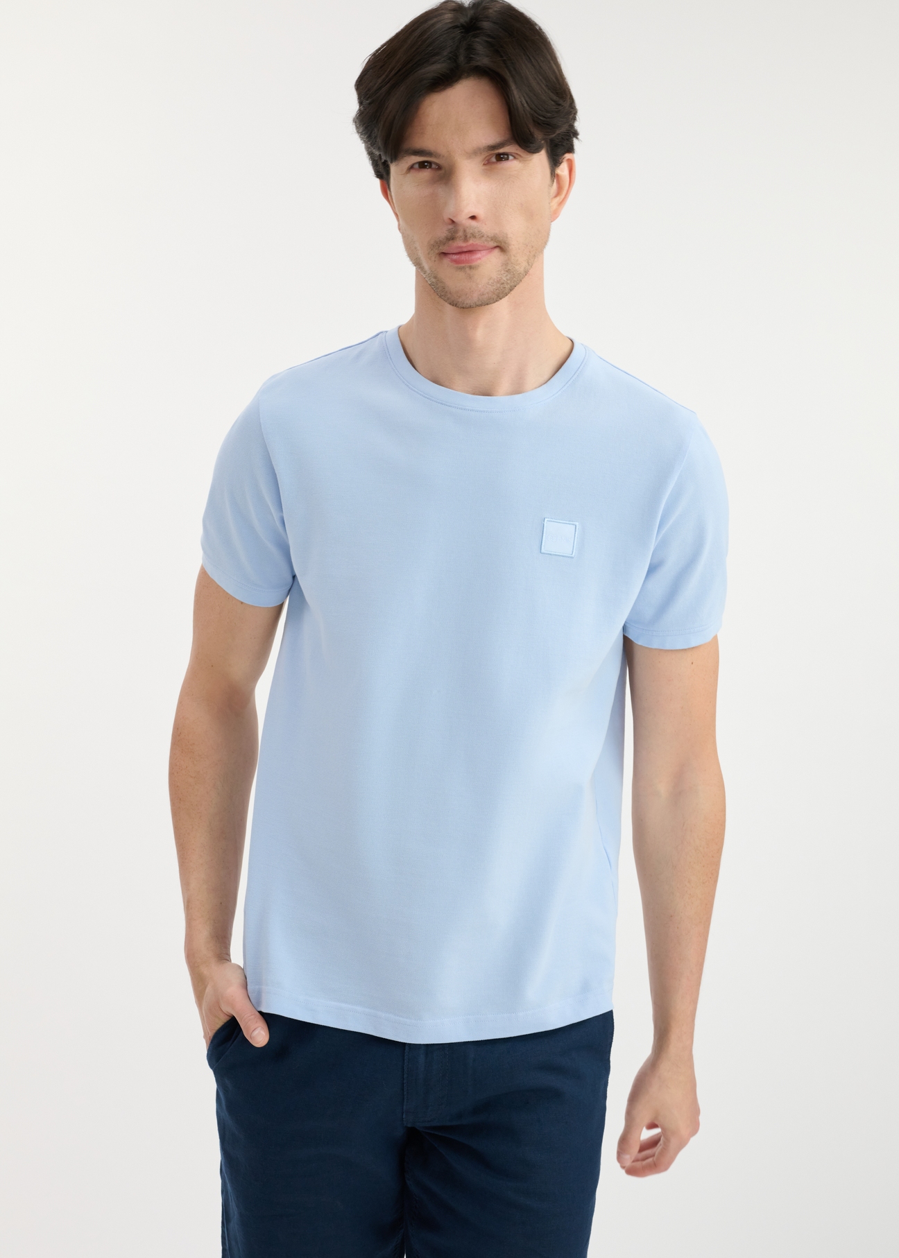 Błękitny T-shirt męski z bawełny TSHMT-0100-60(W25), widok produktu przodem na modelu. Widoczna połowa sylwetki.