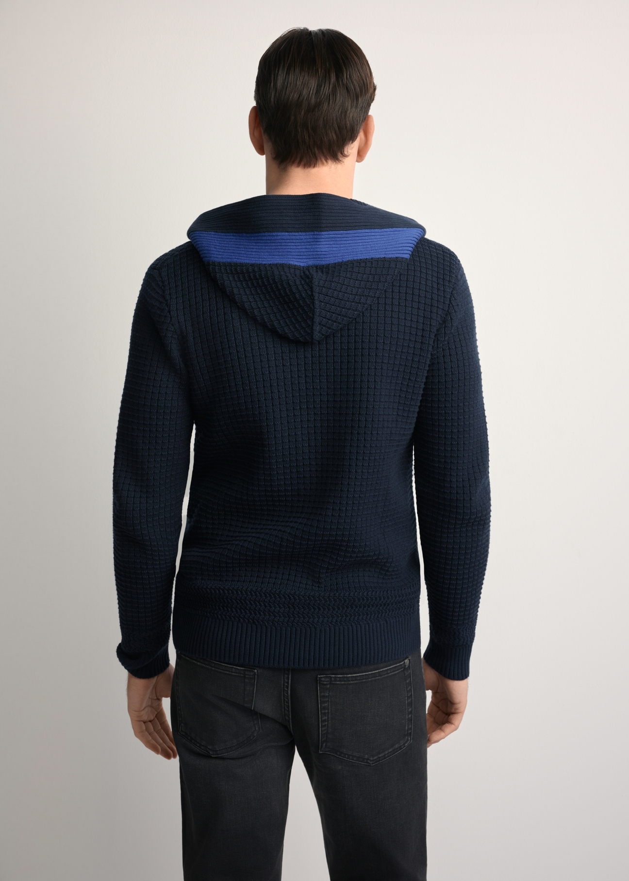 Granatowy sweter męski z kapturem SWEMT-0182-68(Z25), widok produktu z tyłu na modelu. Widoczna połowa sylwetki.