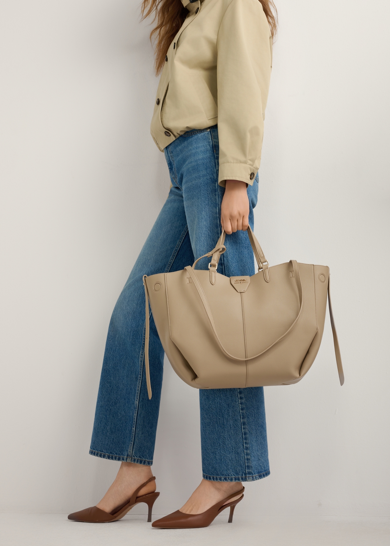 Brązowe czółenka z odkrytą piętą BUTYD-1078A-1D(W26), widok produktu z boku na stopach modelki, na jasnym tle.