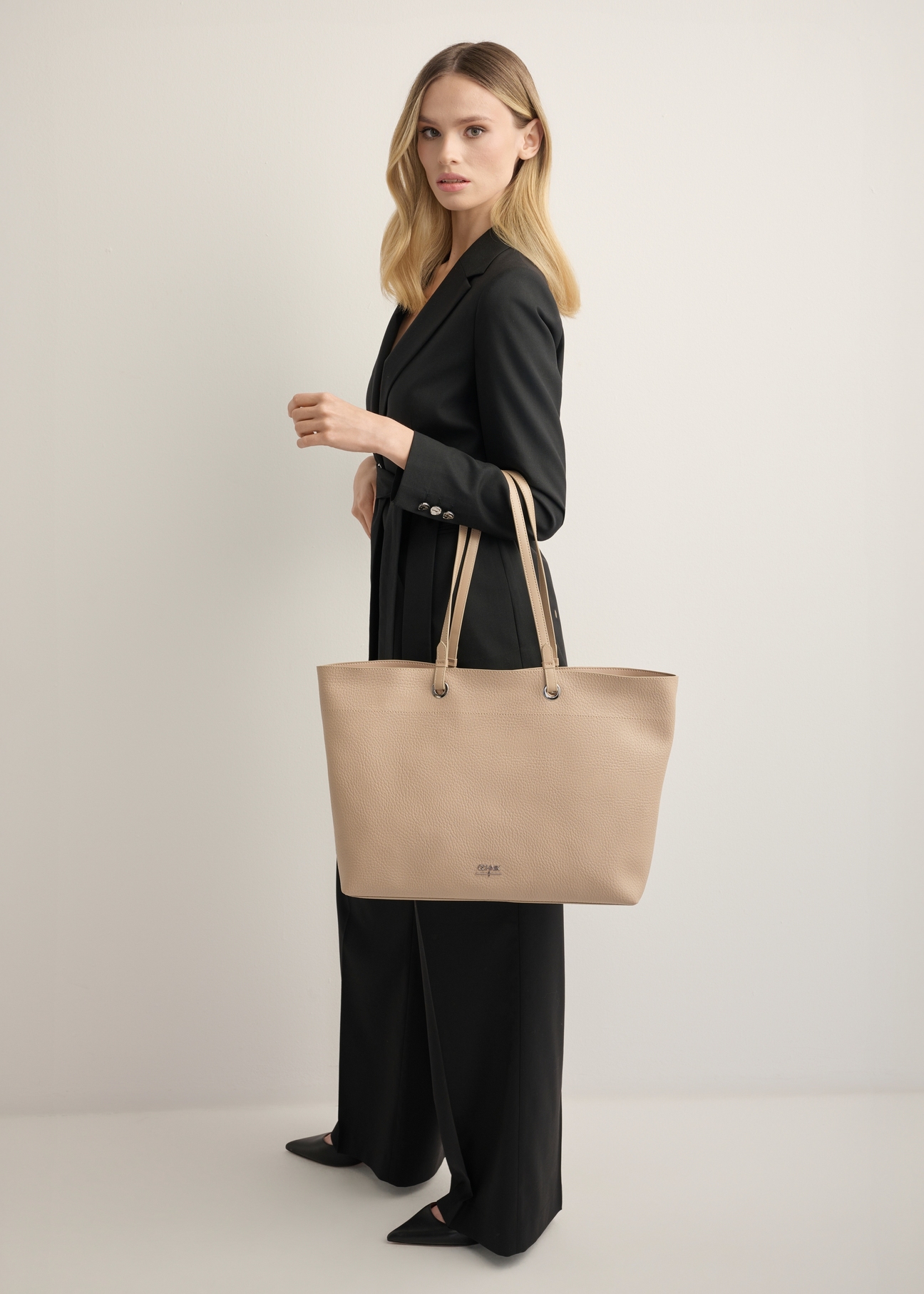 Beżowa groszkowana torebka shopper TOREC-1252-1B(Z26), widok produktu z przodu na modelce. Widoczna cała sylwetka.