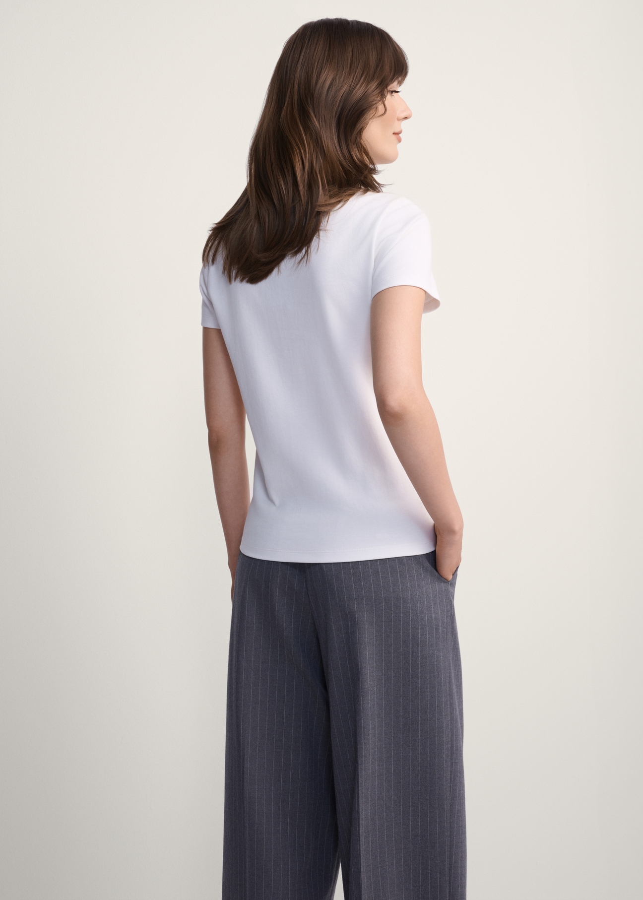 Biały bawełniany t-shirt damski TSHDT-0144-11(Z25), widok produktu od tyłu na modelce, widoczna połowa sylwetki.