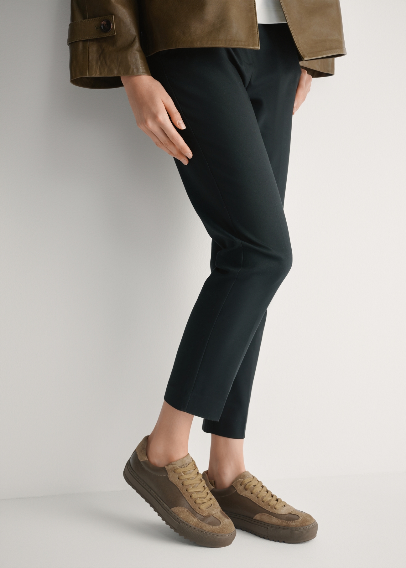 Skórzane tenisówki damskie w kolorze chłodnego beżu BUTYD-1260-1K(W26), widok produktu z boku na stopach modelki.