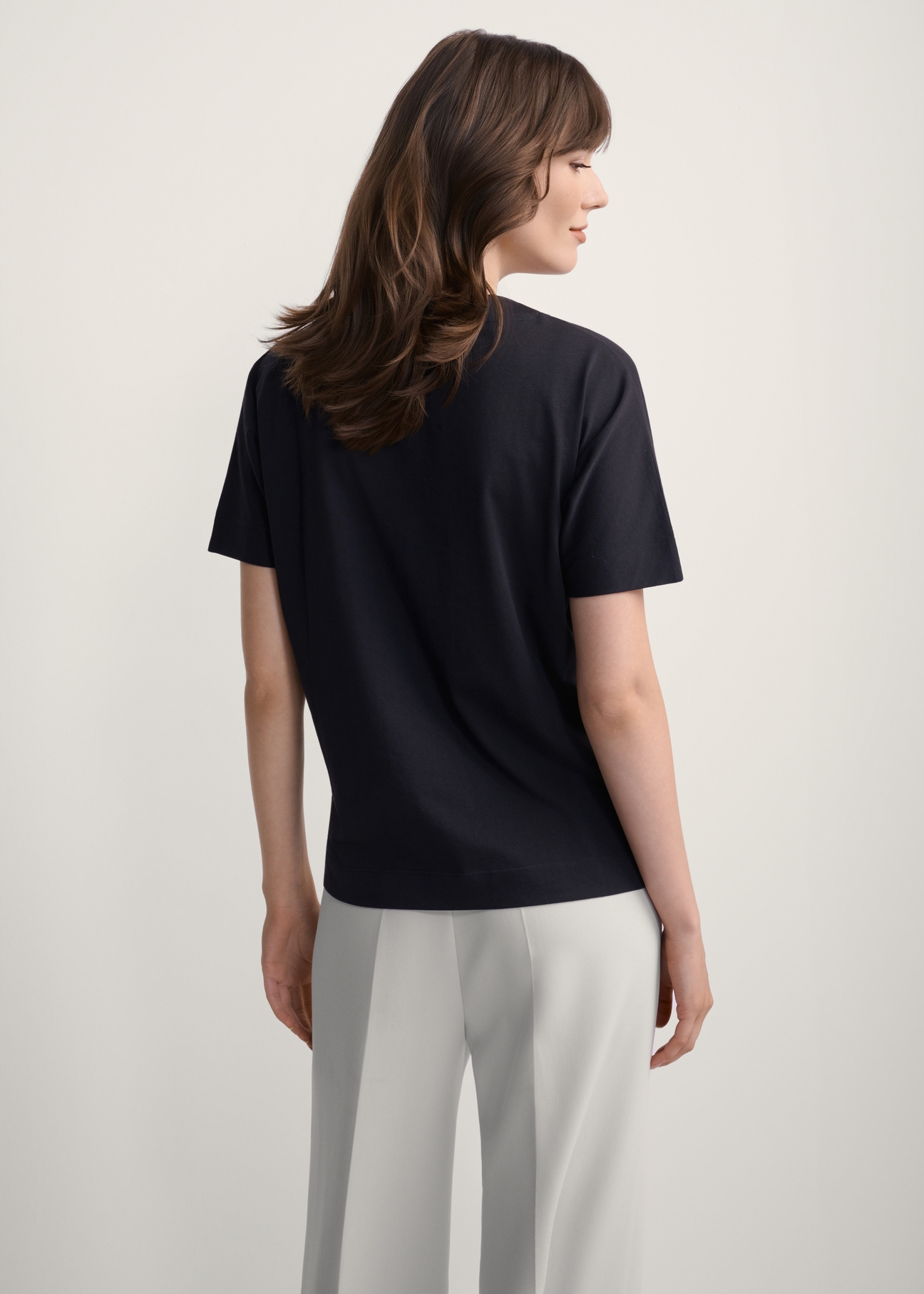 Czarny t-shirt damski z nadrukiem TSHDT-0146-99(Z25), widok produktu z tyłu na modelce. Widoczna połowa sylwetki.