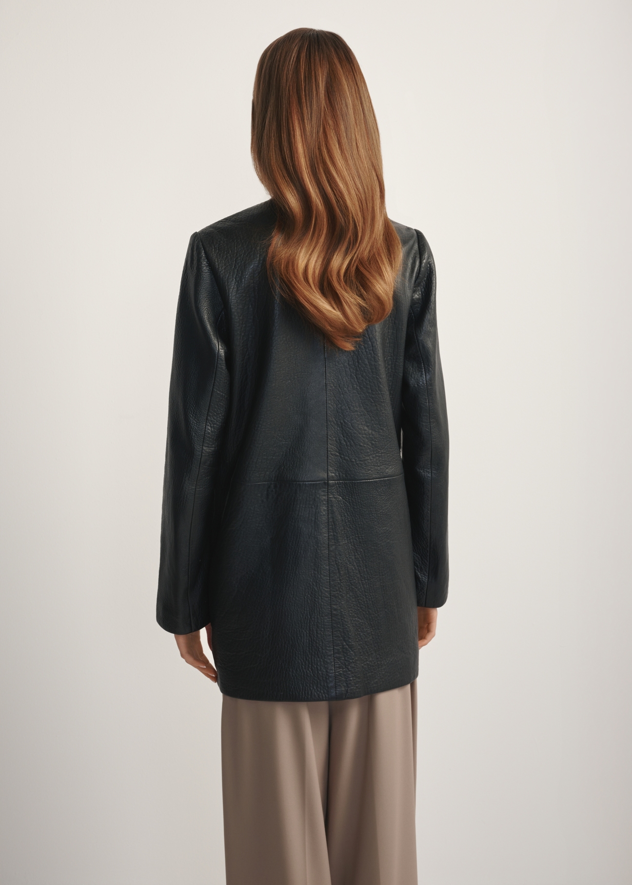 Czarna skórzana kurtka damska KURDS-0583-99(W26), widok produktu z tyłu na modelce. Widoczna połowa sylwetki.