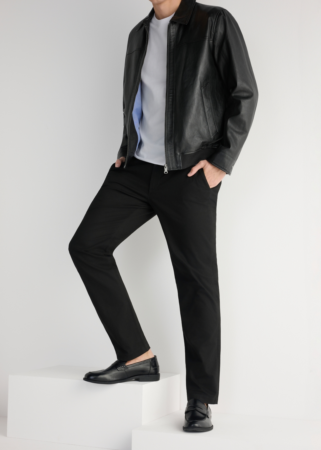 Czarne skórzane mokasyny męskie BUTYM-0482-99(W25), widok produktu od boku na modelu, widoczna połowa sylwetki.