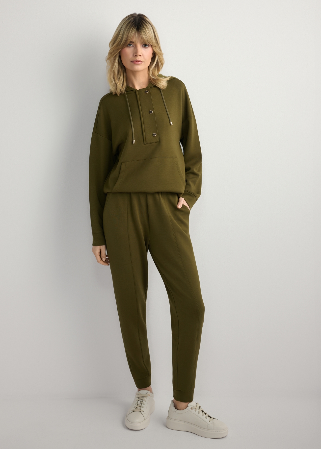 Bluza damska khaki z kapturem BLZDT-0111A-8D(W26), widok produktu z przodu na modelce. Widoczna cała sylwetka.