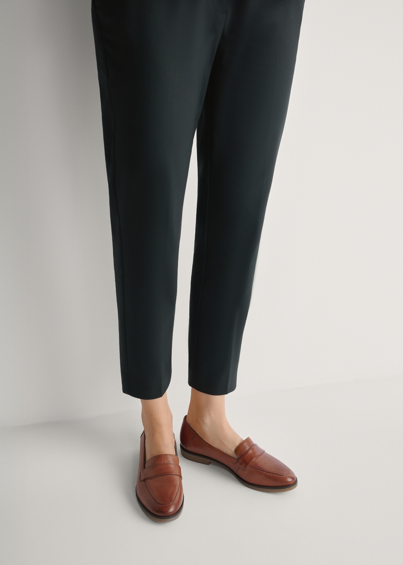 Skórzane mokasyny damskie w kolorze koniaku BUTYD-1067-1F(W26), widok produktu z przodu na stopach modelki.